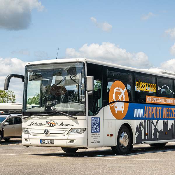 Shuttlebus für den Transport von Düsseldorf nach Weeze mit Verhuven Reisen Logo und Airport Weeze Shuttle Busbeklebung.
