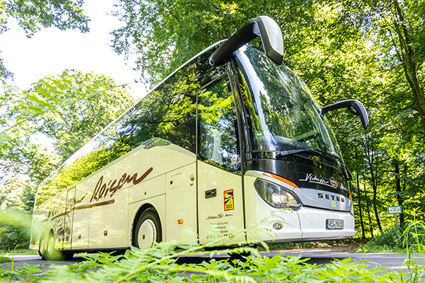 Moderner Reisebus in einer grünen Landschaft im Einsatz für Busreisen und Gruppenreisen.